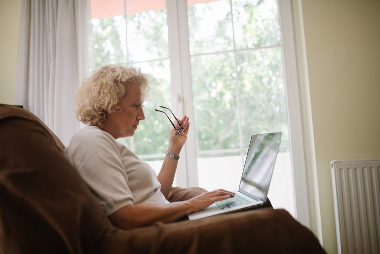 5 Smart Financial Moves to Consider in Your 60s Senior woman reviewing information on a laptop at home while holding her glasses