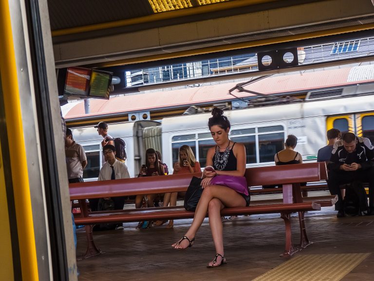 Online Trust Is Becoming a Measurable Thing Commuters reading their smartphones while waiting on a railway station platform.