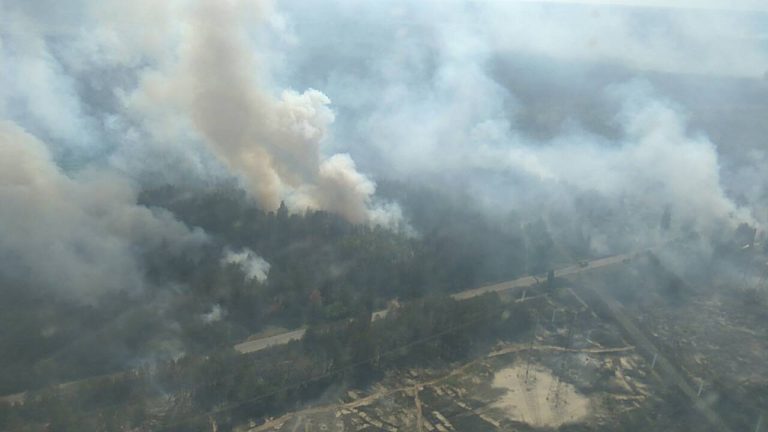 Wildfire Early-Warning Satellites Spot Fires Sooner An aerial view of a wildfire burning through forest with columns of smoke.